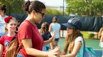 poly summer camp camper and counselor on tennis court